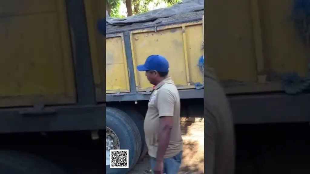 Creator Mistake Dont Just Chase Views CAPTURE Attention shorts - Travel With Glen Man in beige polo and blue cap standing beside a yellow truck trailer with cargo, outdoors. A QR code is on the ground nearby.