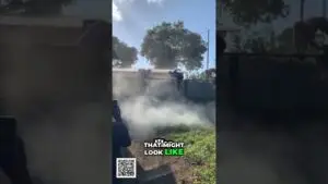 People on a roof above a smoky yard, reaching over a railing as smoke billows below; watermark 'That Might Look Like' with a QR code at the bottom.