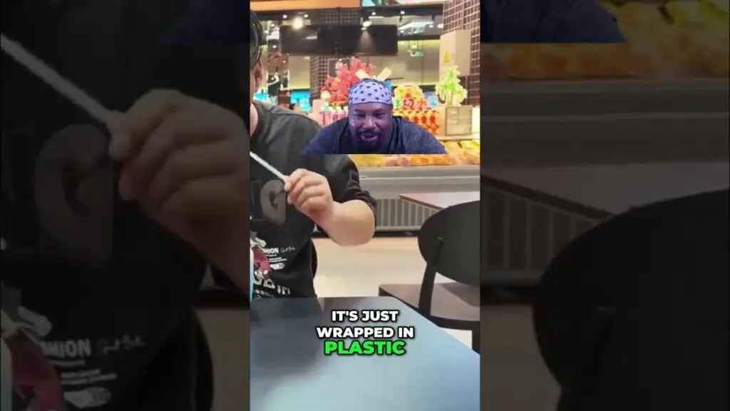 Video shows a man in a star-pattern bandana wrapping an item in plastic at a grocery store; caption reads 'It's just wrapped in plastic'.